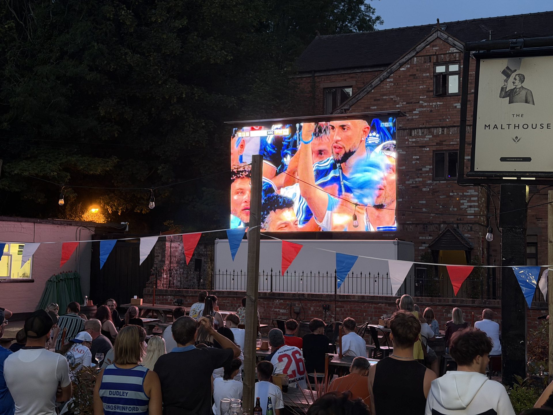 A crowd watching live sport on the Shropshire Screen Hire mobile LED screen at a pub garden