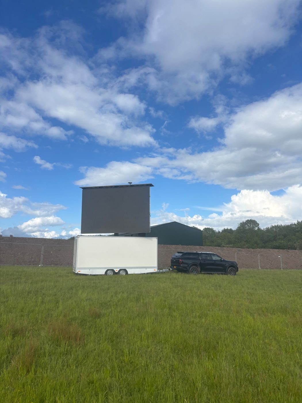 Shropshire Screen Hire trailer-mounted mobile LED screen in a field